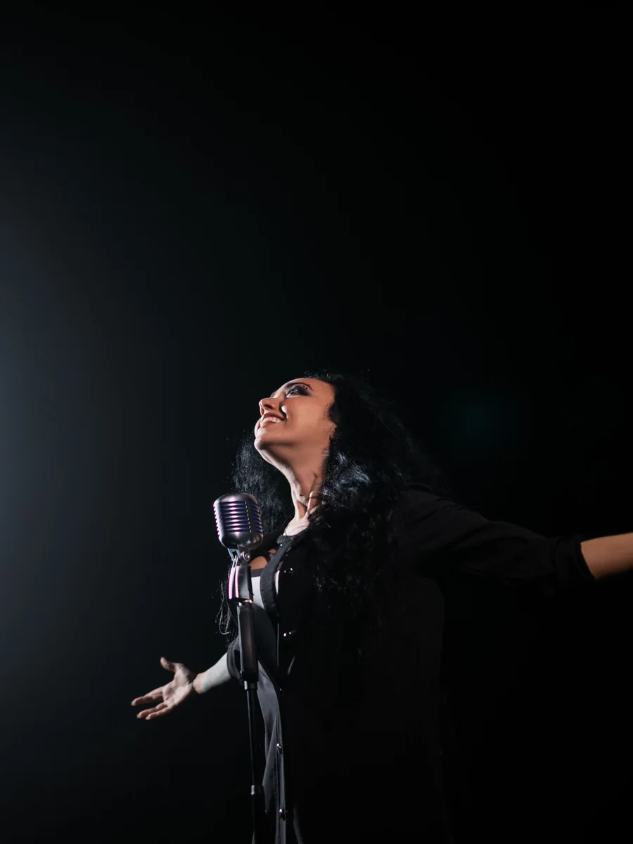 Flamenco śpiewak występujący z pasją w świetle reflektora na ciemnym tle (zdjęcie poglądowe, nie przedstawia własnego zespołu Corral de la Morería)